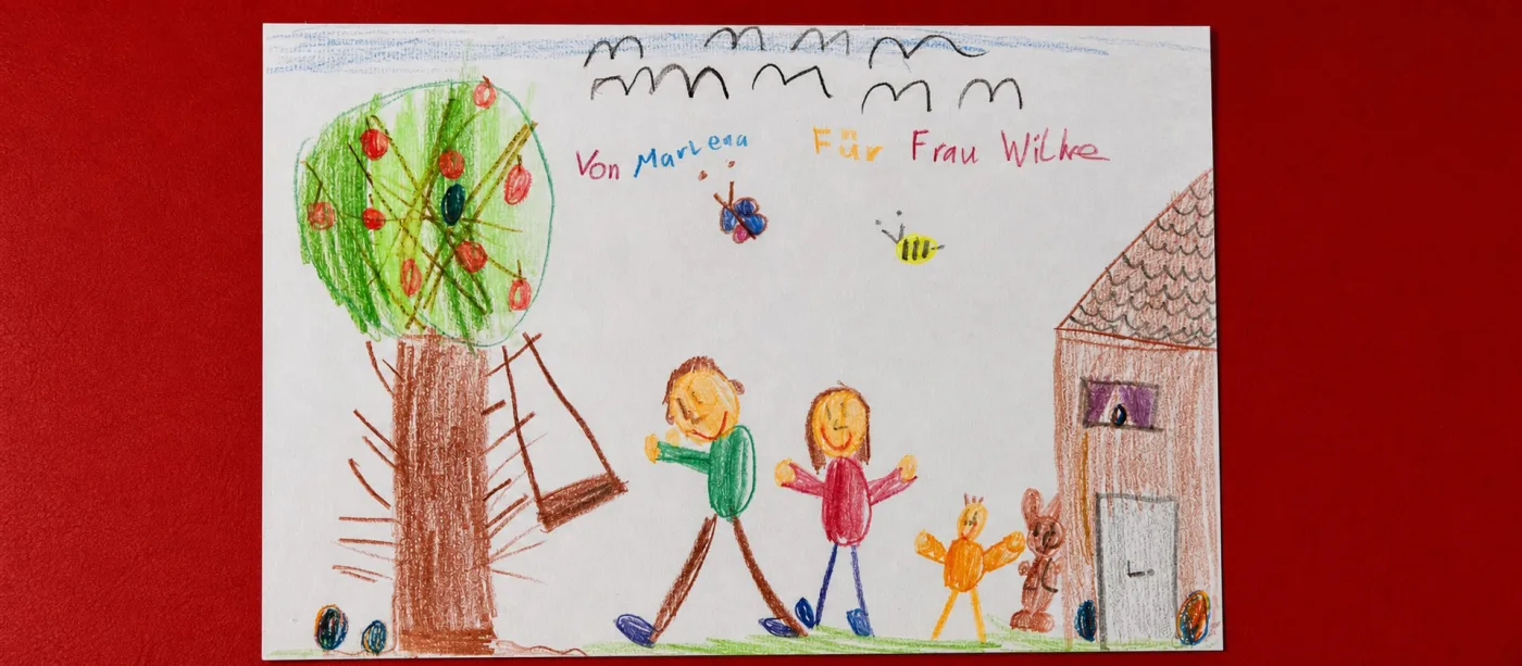 Kinderzeichnung mit Familie vor einem Apfelbaum, gewidmet „Für Frau Wilke“.